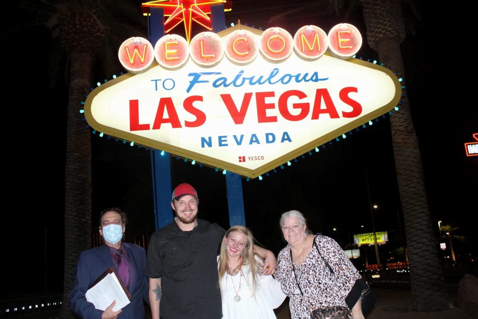 A group of people standing in front of the las vegas sign.